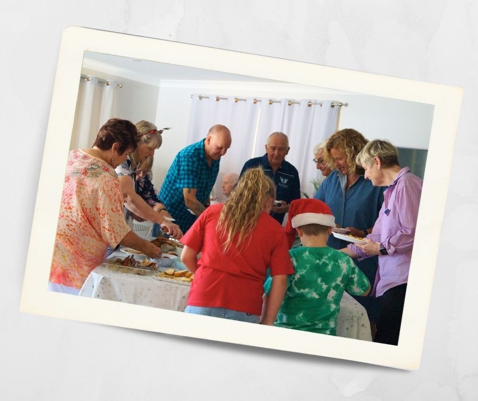 Residents and family members gathered around a table sharing food during a festive visit at Kirkley Gardens, an independent retirement village in Lithgow.
