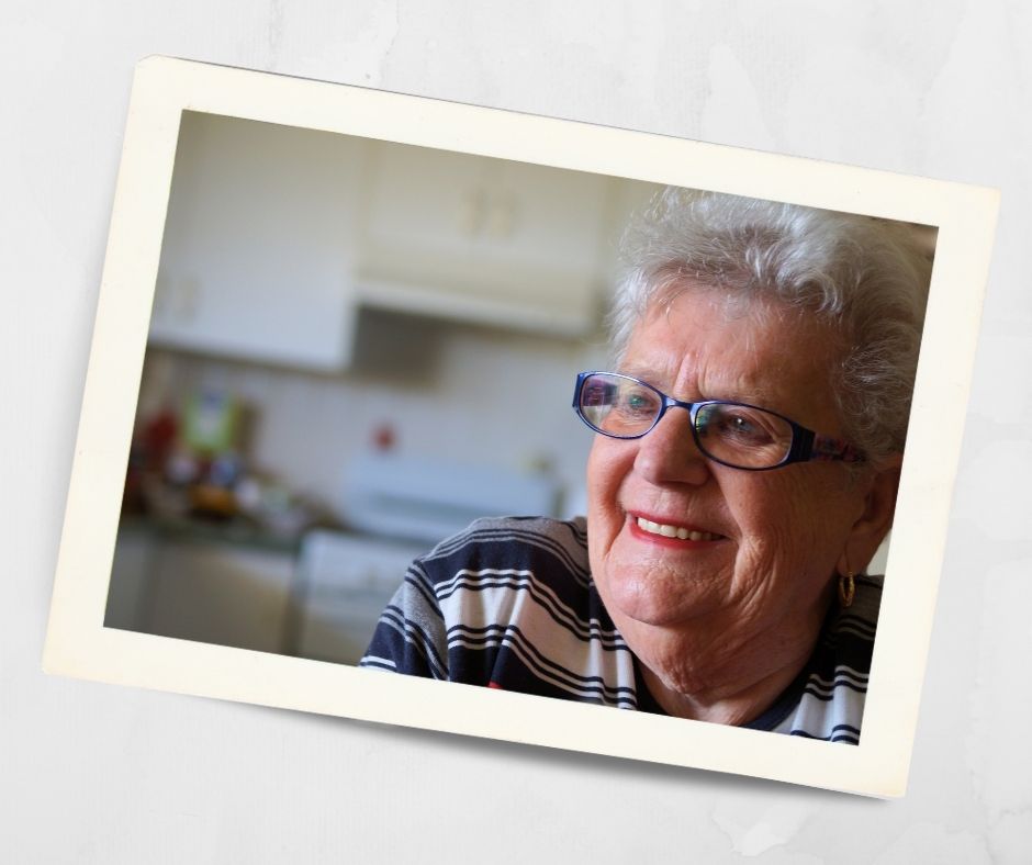 Older woman smiling indoors, wearing glasses, enjoying independent retirement living in a Lithgow NSW retirement village.